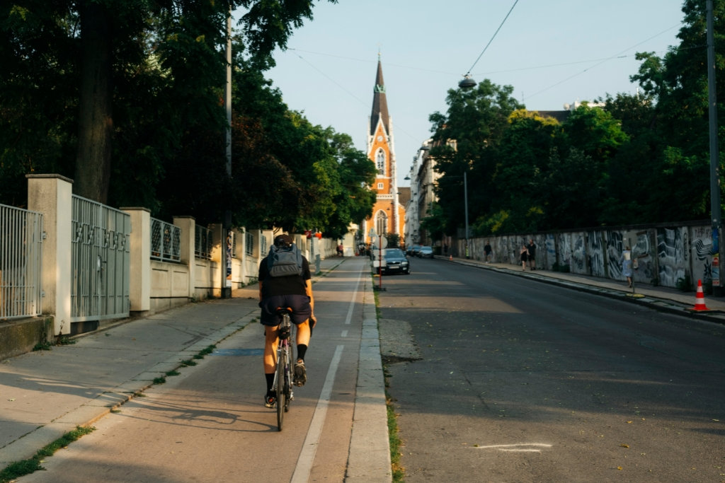 Rennradfahrer auf Radweg mit Kirche im Fluchtpunkt